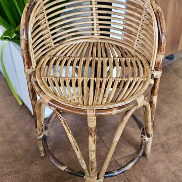 A handmade bamboo armchair on a tiled floor